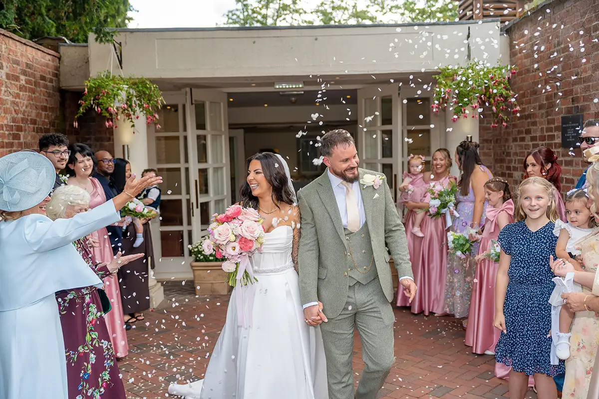 Leila and Mark walking through confetti after their wedding ceremony